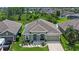 Aerial view of a well-maintained home with lush landscaping, a two-car garage, and surrounded by trees and other homes at 12289 Prairie Plantation Way, Orlando, FL 32824