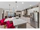 Modern kitchen with a large island, stainless steel appliances, custom cabinets, and stylish lighting fixtures at 12289 Prairie Plantation Way, Orlando, FL 32824