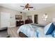 Comfortable main bedroom with wood floors, television, walk-in closet and decorative mirror at 12289 Prairie Plantation Way, Orlando, FL 32824