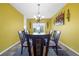 Bright dining room with contemporary chandelier, modern table, and sliding glass door to backyard at 1233 Nelson Park Court, Poinciana, FL 34759