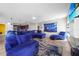 Inviting living room featuring a plush blue sofa, modern decor, and an open concept to the kitchen at 1233 Nelson Park Court, Poinciana, FL 34759