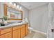 Bathroom features a wood framed mirror, warm wood cabinets and modern lighting at 13505 Phoenix Dr, Orlando, FL 32828