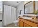 Cozy bathroom featuring a vanity, framed mirror, shower with curtain, and neutral tile flooring at 13505 Phoenix Dr, Orlando, FL 32828