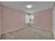 Cozy bedroom with soft carpet, shuttered windows for natural light, and light pink walls creating a serene space at 13505 Phoenix Dr, Orlando, FL 32828