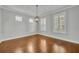 A bright dining room featuring hardwood floors, shuttered windows, and a stylish chandelier at 13505 Phoenix Dr, Orlando, FL 32828