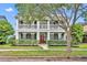 Charming two-story home with a red door, white columns, and a welcoming front porch at 13505 Phoenix Dr, Orlando, FL 32828