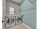 Laundry room with side-by-side washer and dryer and overhead storage shelves at 13505 Phoenix Dr, Orlando, FL 32828