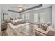 This main bedroom features a tray ceiling, wood floors, a ceiling fan, and doors leading to a balcony at 13505 Phoenix Dr, Orlando, FL 32828