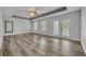 Primary bedroom with hardwood floors, tray ceilings, a ceiling fan, and natural light at 13505 Phoenix Dr, Orlando, FL 32828