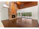 Cozy living room with a brick fireplace, hardwood floors, and a high, wood-paneled ceiling at 140 Margate Mews, Longwood, FL 32779