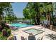 Resort-style pool and hot tub with lounge chairs overlooks the lake on a sunny day at 140 Margate Mews, Longwood, FL 32779