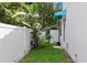 Green backyard with a white fence, tropical plants, and a small patio area at 1429 Indiana Ave, Winter Park, FL 32789