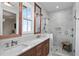 Bathroom featuring double sinks, marble countertops, wood accents, and a glass enclosed shower at 1429 Indiana Ave, Winter Park, FL 32789