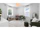 Bright bedroom with two large windows, neutral colors, desk and chair plus a cozy seating area at 1429 Indiana Ave, Winter Park, FL 32789