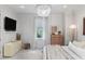A bedroom featuring a television, a hanging chandelier, natural light, and soft, neutral-toned decor at 1429 Indiana Ave, Winter Park, FL 32789