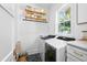 Laundry room with front load washer and dryer, floating shelves, and herringbone tile at 1429 Indiana Ave, Winter Park, FL 32789