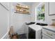 Functional laundry room with modern appliances, herringbone tile flooring, and wood shelves at 1429 Indiana Ave, Winter Park, FL 32789
