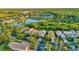 Scenic aerial view of a residential community with a lake, lush trees, and well-maintained homes at 149 Acadia Dr, Kissimmee, FL 34759