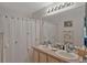 Bright bathroom with a double vanity, large mirror, and shower with decorative curtain at 149 Acadia Dr, Kissimmee, FL 34759
