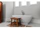 Relaxing bathroom with a freestanding tub, bench, and three windows at 1590 Harston Ave, Orlando, FL 32814