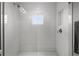 Modern walk-in shower featuring white subway tile, a herringbone tile floor, and a window for natural light at 1590 Harston Ave, Orlando, FL 32814