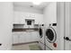 Bright laundry room featuring new appliances and plenty of cabinet storage at 1590 Harston Ave, Orlando, FL 32814