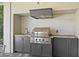 Close up view of the outdoor kitchen with stainless steel grill and ample counter space at 1590 Harston Ave, Orlando, FL 32814