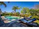 Inviting pool with lounge chairs surrounded by lush tropical landscaping and an open sky at 1590 Harston Ave, Orlando, FL 32814