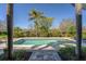 Beautiful in-ground pool surrounded by lush landscaping and palm trees, creating a private backyard oasis at 1590 Harston Ave, Orlando, FL 32814