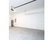 View of the spacious garage with concrete flooring, white walls and water heater at 15998 Sw 33Rd Avenue Rd, Ocala, FL 34473