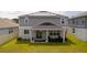 Backyard of a home with a covered patio and solar panels on the roof at 1631 Pontiff Pl, Davenport, FL 33896