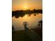 Breathtaking golden sunrise reflecting off the tranquil lake from the backyard, offering a peaceful retreat at 1631 Pontiff Pl, Davenport, FL 33896
