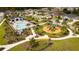 Aerial view of community pool and playground featuring lush landscaping and walking paths at 1631 Pontiff Pl, Davenport, FL 33896