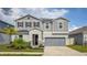 Two-story home with gray siding, stone accents, and a manicured lawn showcasing curb appeal at 1631 Pontiff Pl, Davenport, FL 33896