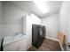Laundry room with sleek black washer and dryer set, white cabinets, and a herringbone backsplash at 1631 Pontiff Pl, Davenport, FL 33896