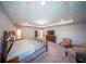 Comfortable main bedroom featuring an elegant tray ceiling, soft lighting, and cozy seating at 1631 Pontiff Pl, Davenport, FL 33896