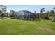 Expansive backyard showcasing a screened pool, lush lawn, and serene views at 169 Mallard Ln, Daytona Beach, FL 32119