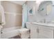 Cozy bathroom with a shower-tub combination, a round mirror and neutral-colored tile at 169 Mallard Ln, Daytona Beach, FL 32119