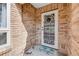 Enclosed front porch with custom white security door and neutral brick exterior at 169 Mallard Ln, Daytona Beach, FL 32119