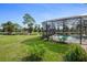 Screened-in pool surrounded by well-maintained landscaping and overlooking a pond at 169 Mallard Ln, Daytona Beach, FL 32119