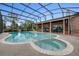 Screened-in pool area featuring a large pool, spa, and outdoor patio with a backyard view at 169 Mallard Ln, Daytona Beach, FL 32119