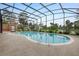 Screened-in swimming pool, surrounded by lush landscaping and a view of the lake at 169 Mallard Ln, Daytona Beach, FL 32119