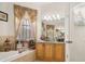 Bright bathroom featuring a vanity with granite countertops and an ornate, decorative window treatment at 2002 Adair St, Ocoee, FL 34761