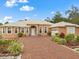 Captivating single-story home with a brick driveway, manicured landscaping, arched entryway, and durable metal roof at 2002 Adair St, Ocoee, FL 34761