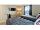 Well-lit bedroom with a dresser, TV, and two twin beds for versatile living, perfect for relaxation at 202 Napoli Dr # 202, Davenport, FL 33897