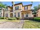 Inviting two-story condo featuring a stucco facade, manicured landscaping, and a welcoming entrance at 202 Napoli Dr # 202, Davenport, FL 33897