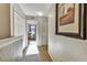 Bright hallway featuring neutral paint and carpet flooring, leading to a bedroom with a patterned chair at 202 Napoli Dr # 202, Davenport, FL 33897