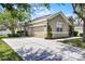 Exterior view of home with a two-car garage and a long driveway at 2024 Beardsley Dr, Apopka, FL 32703