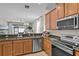 Modern kitchen with stainless steel appliances, wood cabinets, and granite countertops at 2024 Beardsley Dr, Apopka, FL 32703