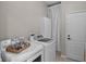 Functional laundry room with washer, dryer, storage cabinet, and a door leading to another part of the home at 2024 Beardsley Dr, Apopka, FL 32703